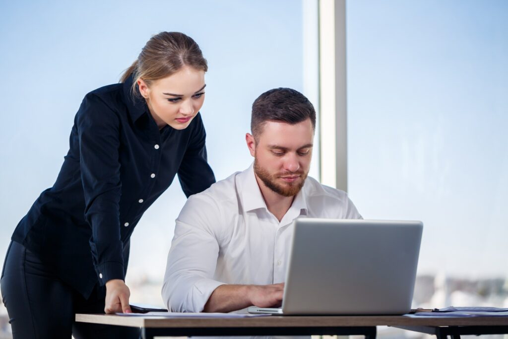 Colleagues collaborating at a modern office workstation.