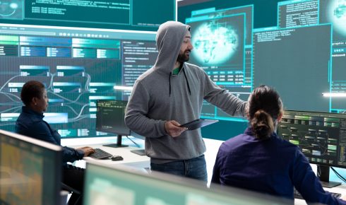 Government hackers analyzing data to detect cyber threats, looking at a large screen in a high-tech office. Focus on cyber intelligence, online security, and the prevention of digital threats.
