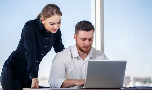 Colleagues collaborating at a modern office workstation.
