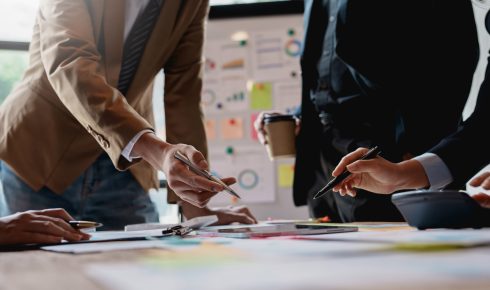 Group of businesspeople meeting and presenting, discussing and analyzing data, pointing to charts and graphs of finance and accounting, business ideas for future growth.