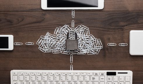 Cloud service data security concept: a computer, tablet, phone, and hard drive connected to the cloud, made of white paper clips with a check-lock on them