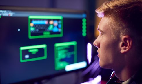 Person working on computer with code displayed.